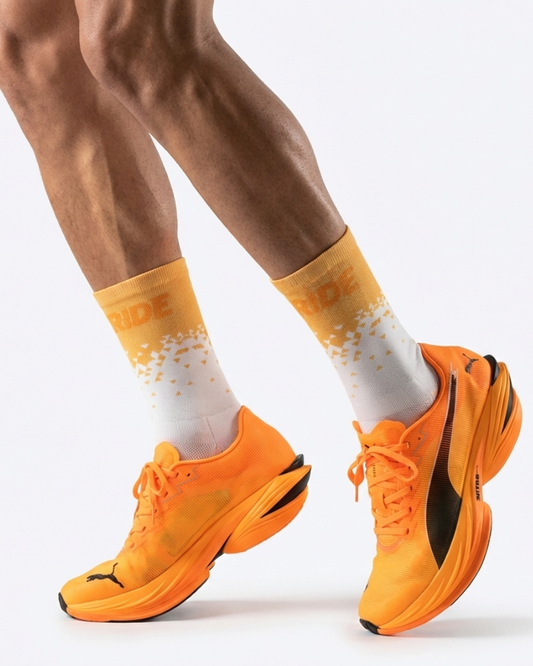 Orange running shoes with white socks featuring orange patterns on a white background