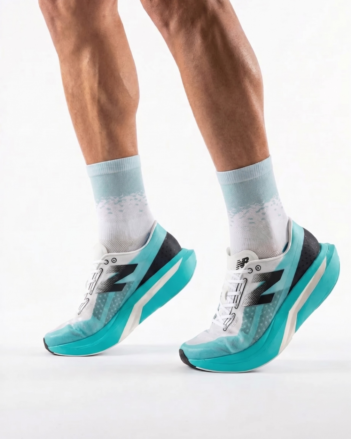 Teal running shoes with white soles worn by a person on a light gray background