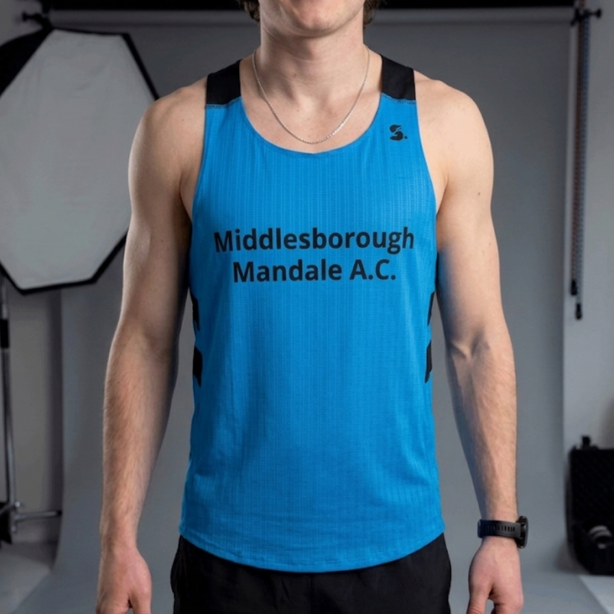 Person wearing a blue tank top with text in a studio setting