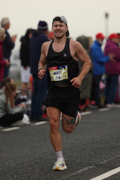 Man running in a marathon with spectators on the side