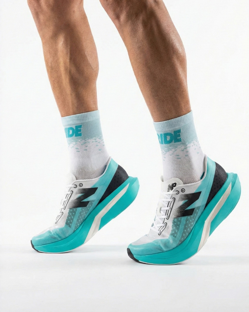 Teal running shoes with white soles worn by a person on a light gray background