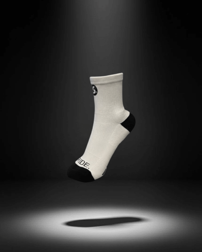 A white sock with a black heel and toe, featuring a small logo near the cuff.