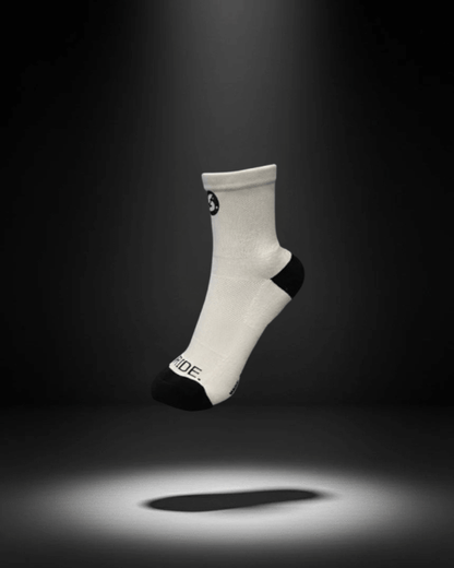 A white sock with a black heel and toe, featuring a small logo near the cuff.