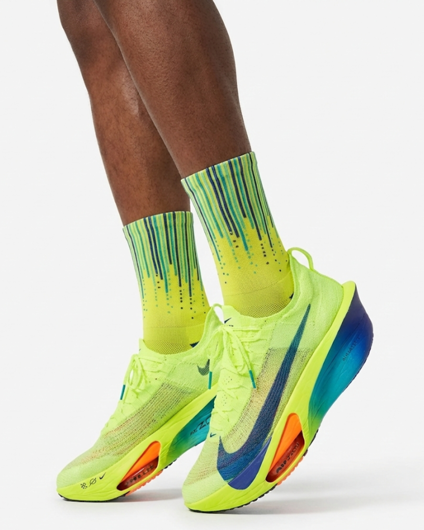Neon green and blue running shoes with matching socks on a white background